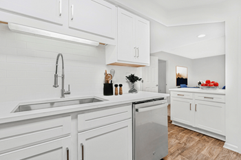 a kitchen with white cabinets and a stainless steel dishwasher at Caveness Farms Apartments, Wake Forest, NC 27587